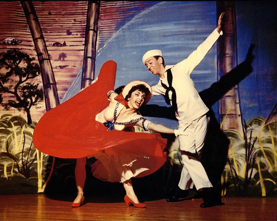 Dean and a partner dancing on a colorful stage set