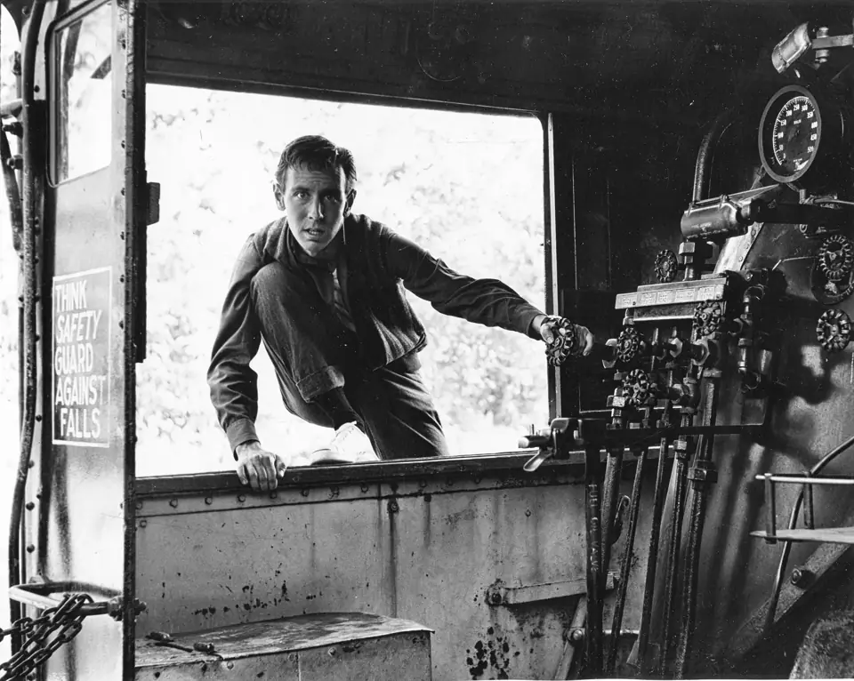 Young Dean climbing through the window of a locomotive cab